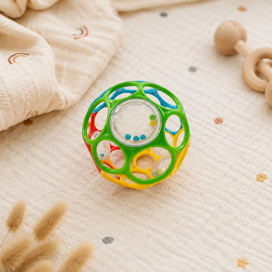 Colorful baby toy rattle on a soft surface with wooden toys in the background