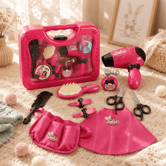 Pink toy hair salon set with tools and accessories on a carpeted floor.