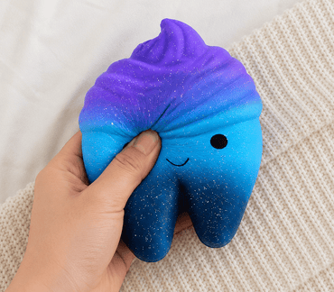 Blue and purple gradient squishy toy with a smiley face held in a hand on a textured surface, stress relief toy for kids