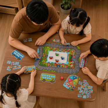 A family of four playing a colorful children's bus-themed board game around a wooden table. The game board features a winding road with various colorful buses, houses, and traffic lights, surrounded by players' hands and cards.