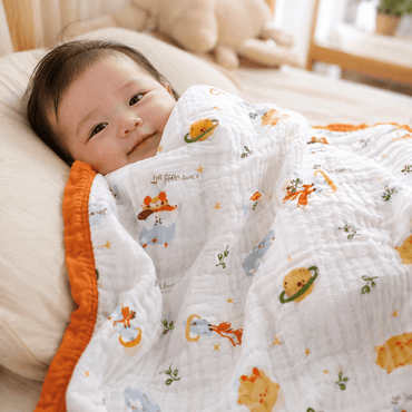 Baby wrapped in Universe pattern cotton gauze swaddle blanket with orange trim