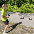 Boy using the remote control to drive the 4WD RC monster truck on an outdoor path