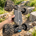 Close-up of the 4WD RC monster truck's metal-reinforced underside and drivetrain covered in dirt