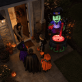 Kids trick-or-treating at the front door next to the glowing witch cauldron bubbling potion Halloween inflatable