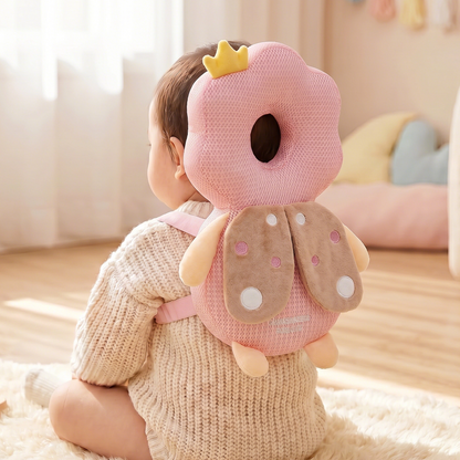 Baby wearing a pink donut-shaped head support pillow in a cozy room.