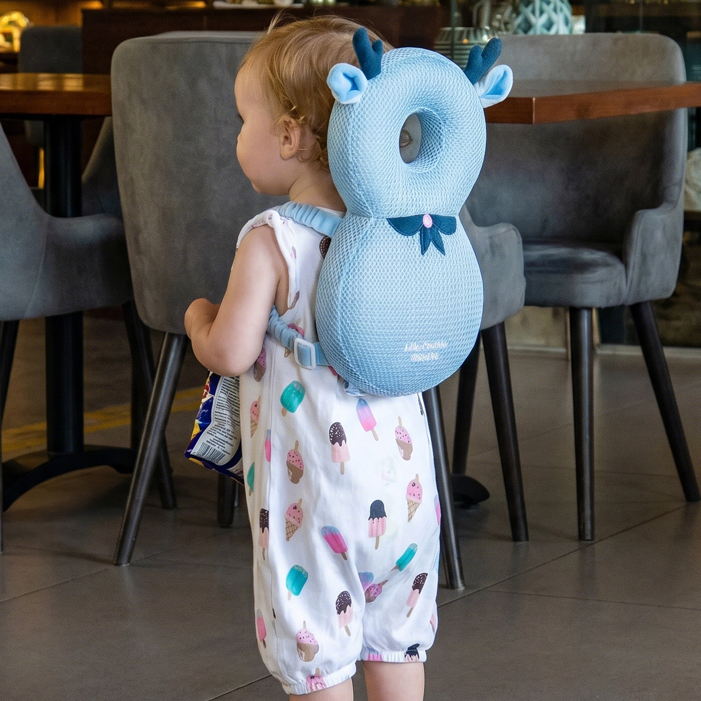Child wearing a blue animal-shaped backpack head protector