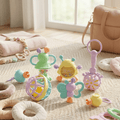 Colorful baby toys on a carpeted floor with a pink bag in the background.