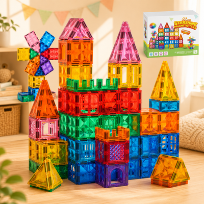 A set of colorful translucent magnetic building blocks arranged in a castle-like structure on a wooden floor, with the product box shown in the upper right corner.