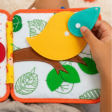 Toddler pressing felt bird page on quiet book — sensory activity for babies