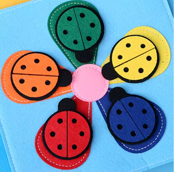 Colorful ladybug-shaped stickers on a soft early learning book