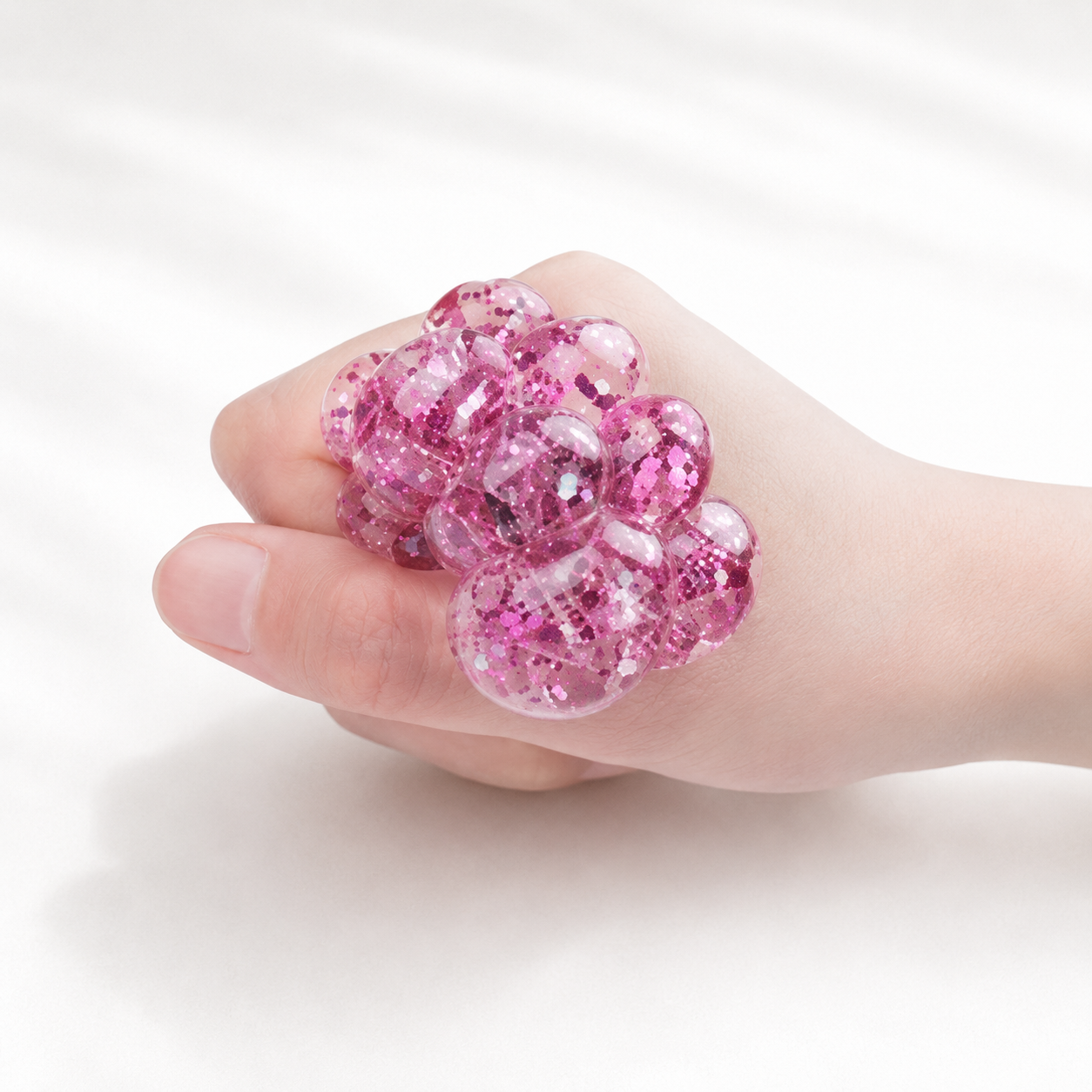 A child's hands squeezing a multi-textured sensory ball