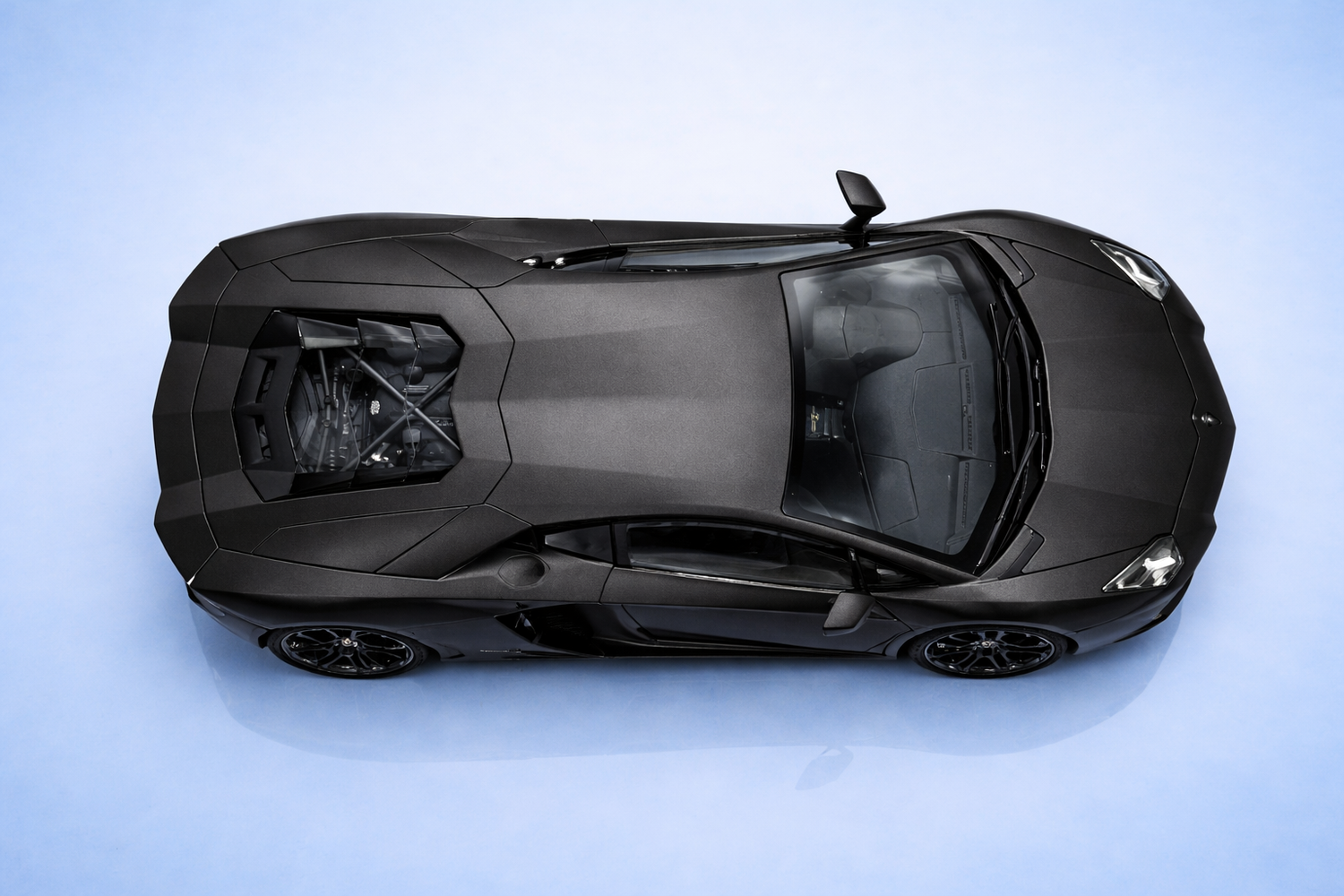 Top-down view of a black sports car on a light blue background