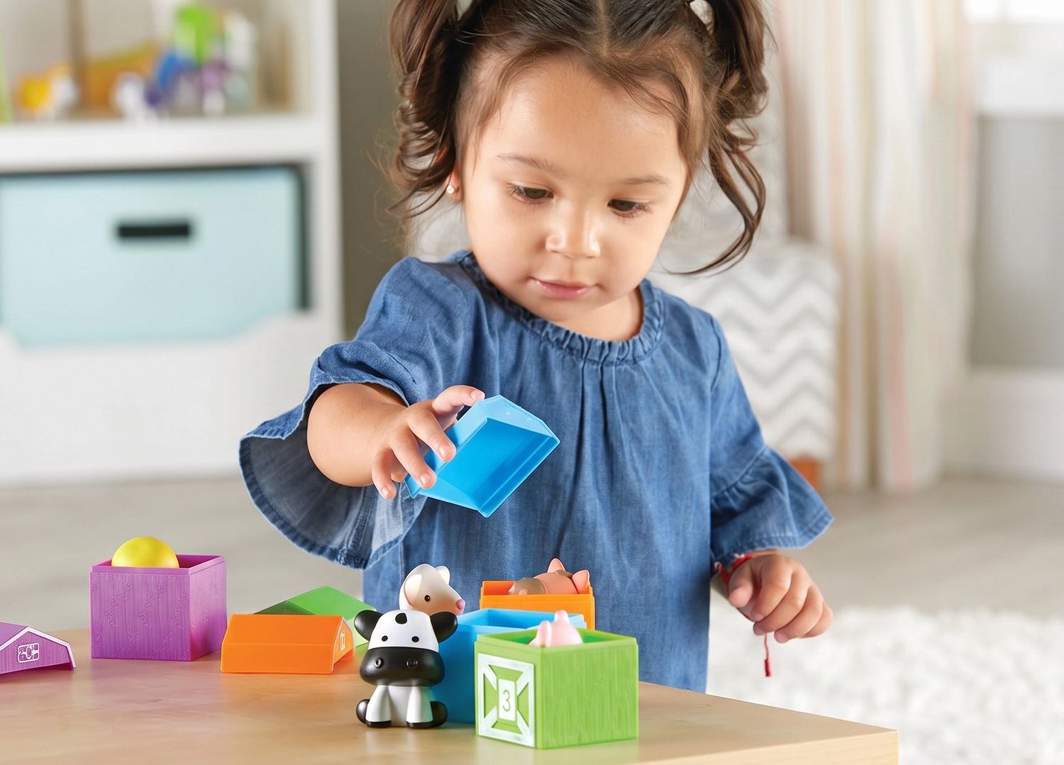Child playing with colorful blocks on a table in a room,  Fine Motor Learning for Ages 18M+ 