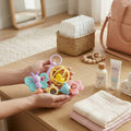 Baby toys and essentials on a wooden surface with a neutral background