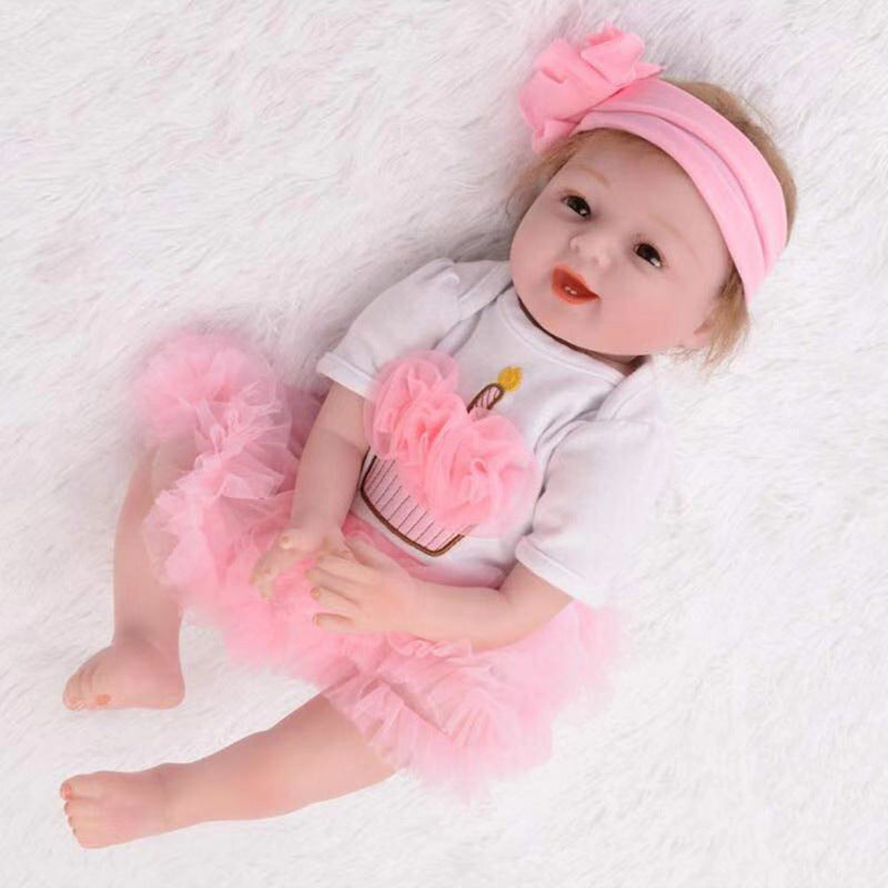 Baby doll in a pink outfit with a headband on a white textured surface