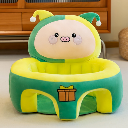 Green and yellow plush toy with cartoon face on a wooden floor