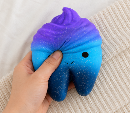 Blue and purple gradient squishy toy with a smiley face held in a hand on a textured surface, stress relief toy for kids