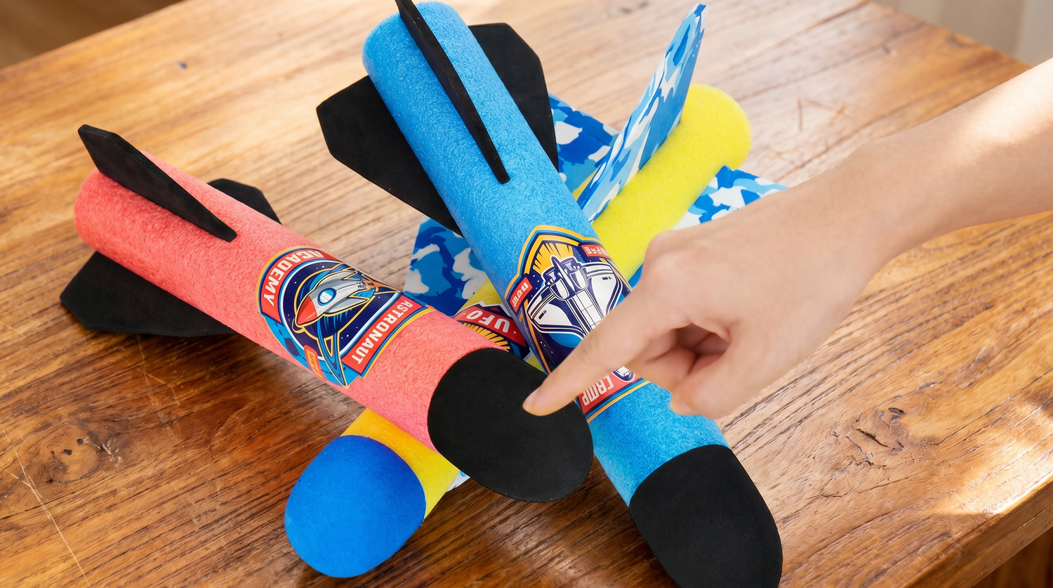 Colorful foam glider toy rockets on a wooden surface