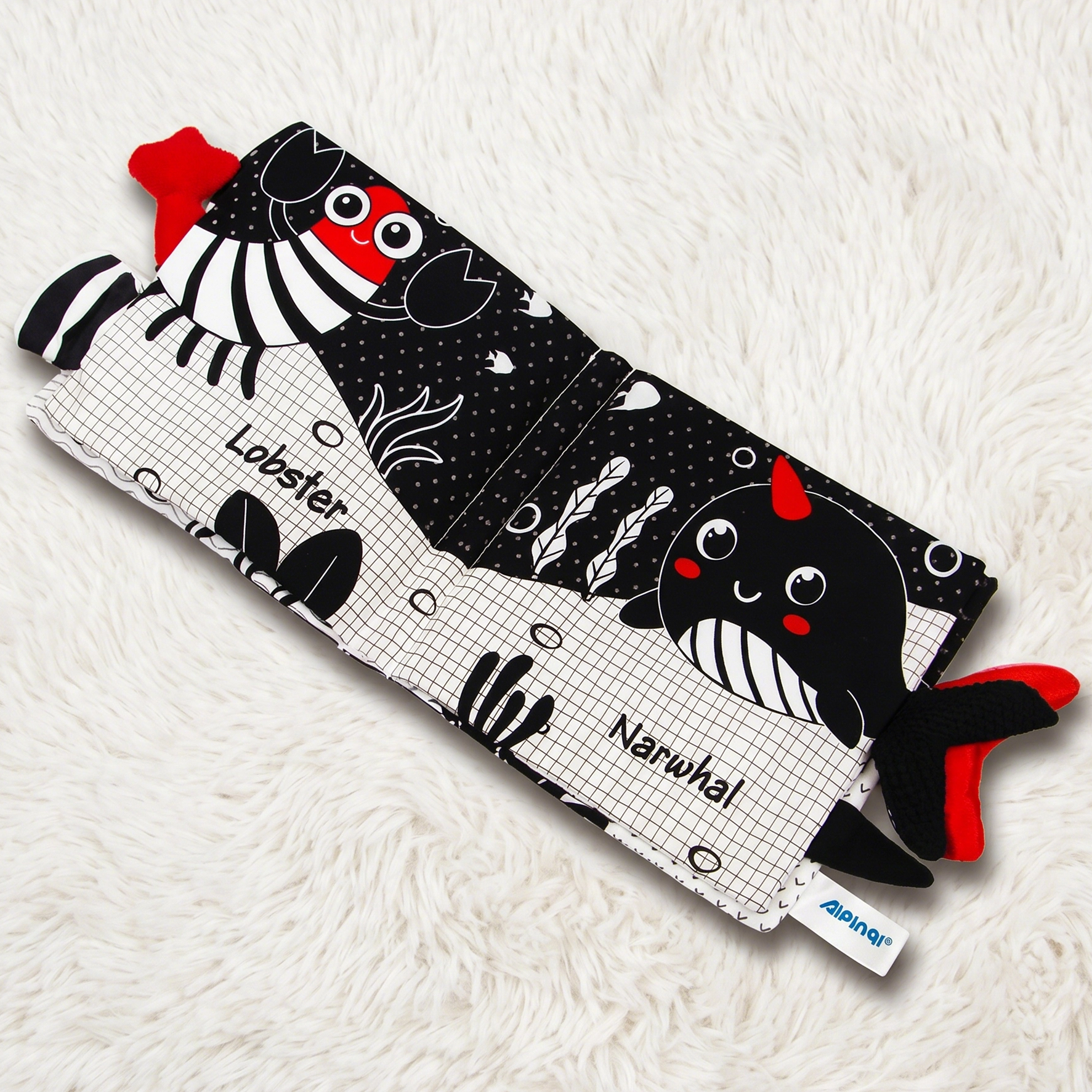 Children's book with lobster and narwhal illustrations on a white textured surface