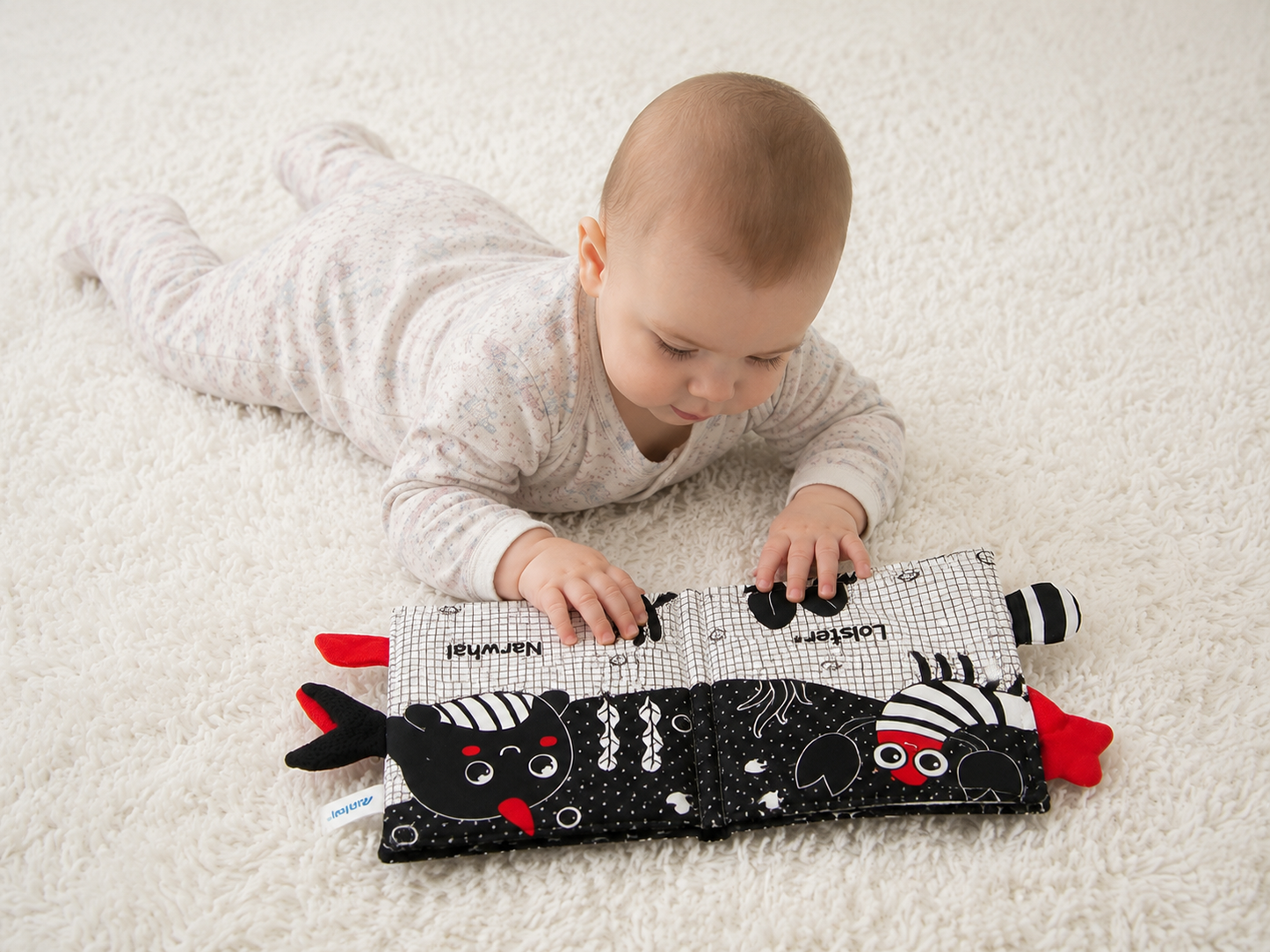 Baby playing with a soft toy on a white carpet