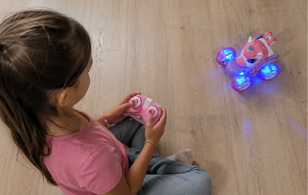 Child playing with a toy rc car on a using remote control joystick