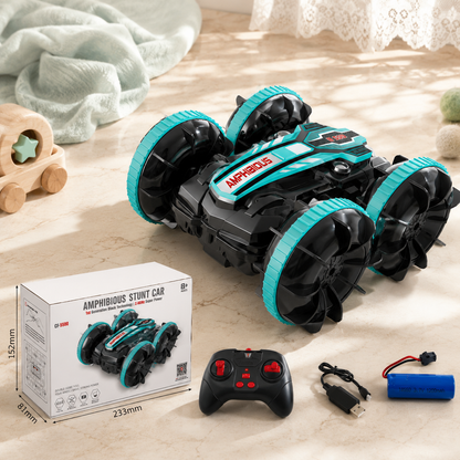 Amphibious stunt car with remote control, battery, and packaging on a wooden surface.