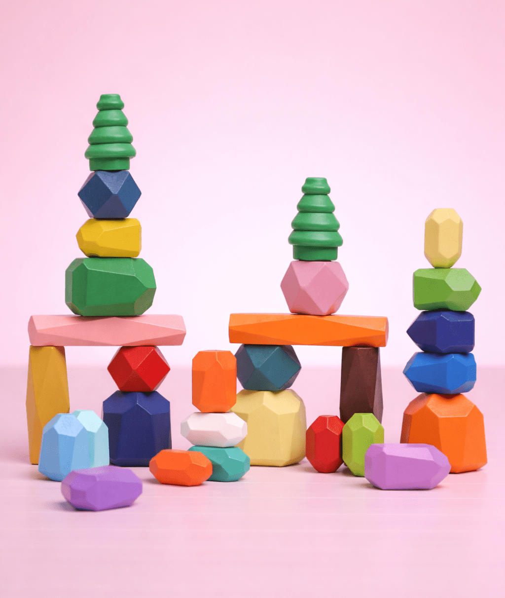 Colorful wooden balancing stones arranged into multiple stacked towers with tree-shaped pieces and arches.