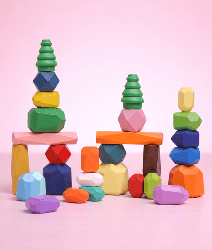 Colorful wooden balancing stones arranged into multiple stacked towers with tree-shaped pieces and arches.