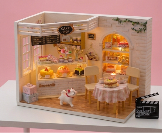 Miniature model of a cake shop with illuminated interior on a pink background