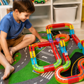 Child building a layout with the electronic train magnetic track set in a playroom