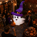 Kids and parents in costumes with the ghost Halloween yard inflatable at a backyard party
