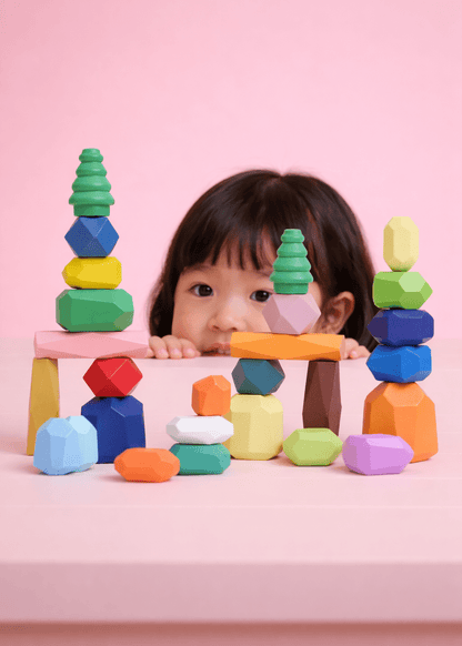 Girl peeking over stacked towers of wooden balancing stones.