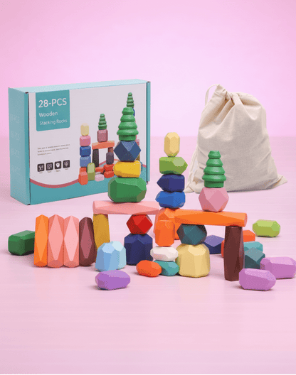 Wooden stacking rocks balancing toy set on a pink background.