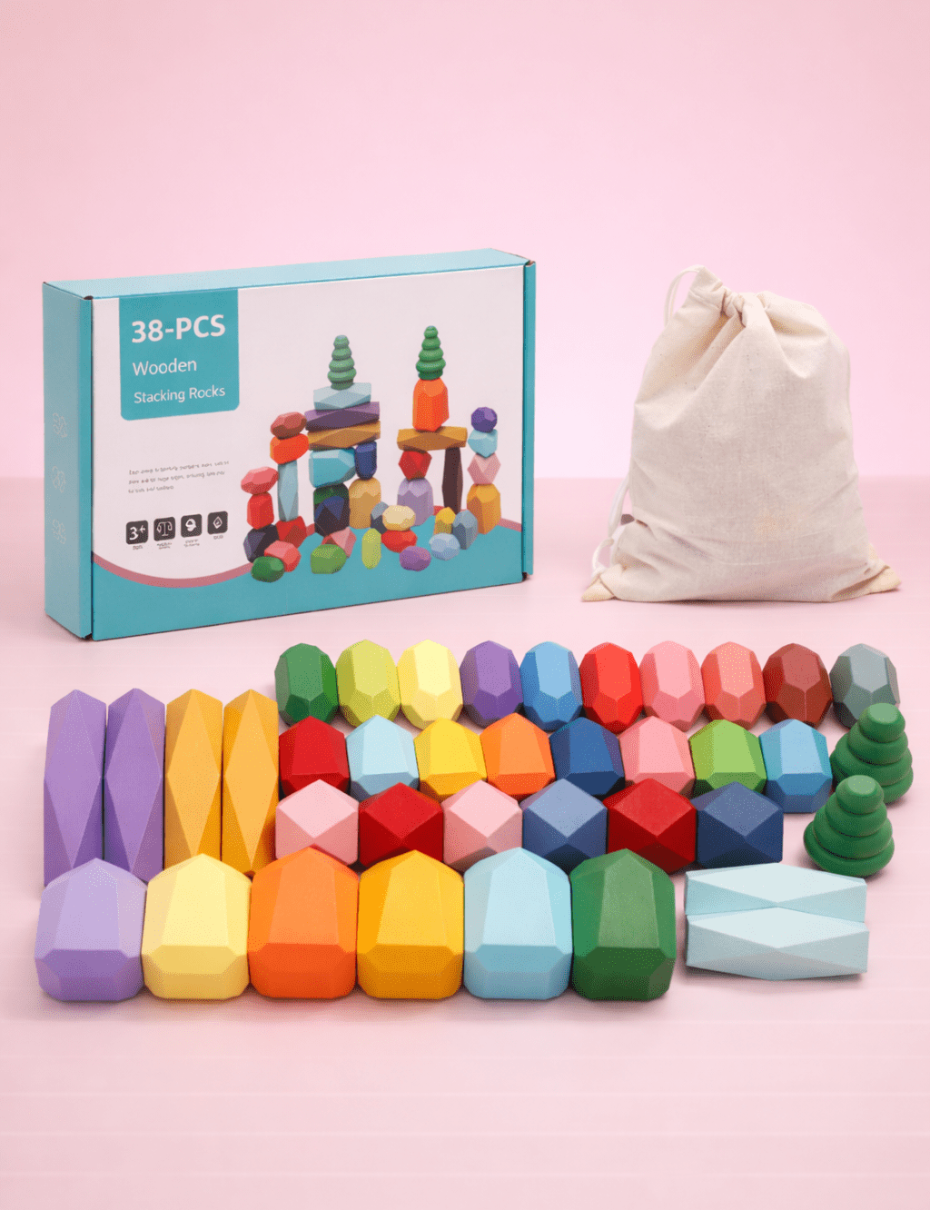 Colorful wooden balancing stones with retail packaging and drawstring storage bag on a pink background.